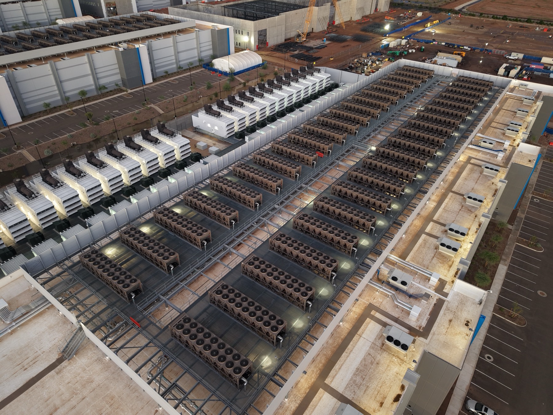 Cooling equipment, pipes, and paved surfaces on the roof and grounds of a large data center complex.